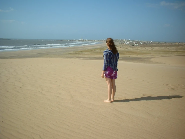 a girl on the beach looking out to the ocean