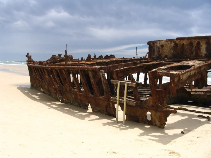 a big ship is laying on a sandy beach