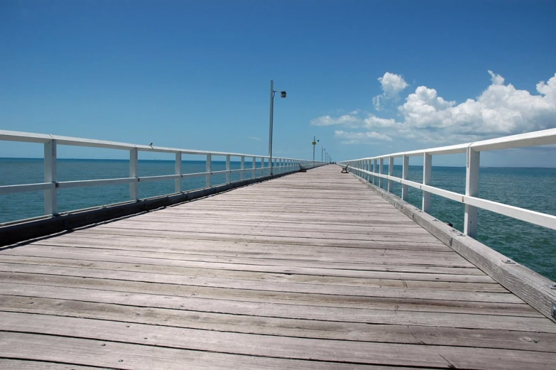 a boardwalk stretching out onto the water to the sea