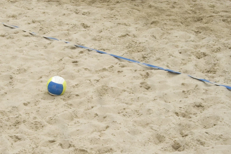 a ball on a beach that has blue and white lines