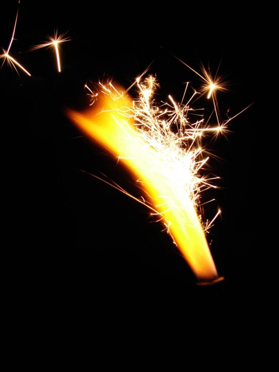 a sparkler light up in the dark with a black background
