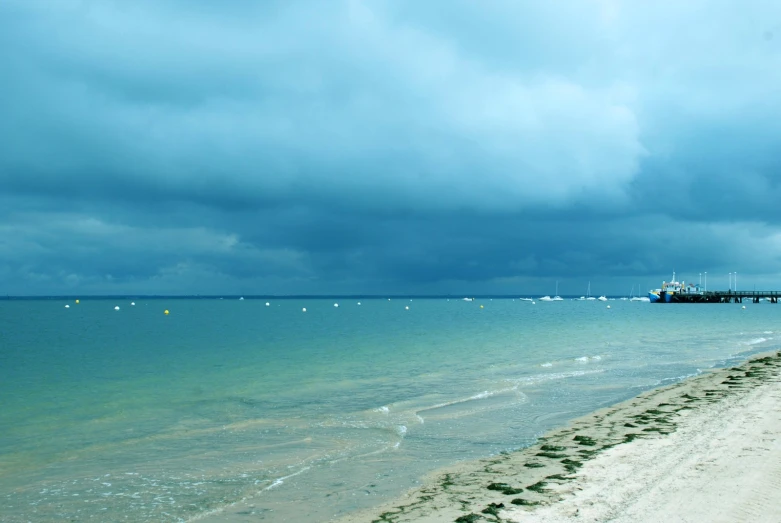 the water is clear with boats near a beach