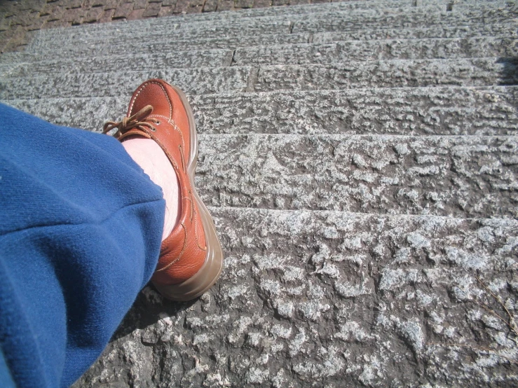 person with shoes on walking up a concrete walkway