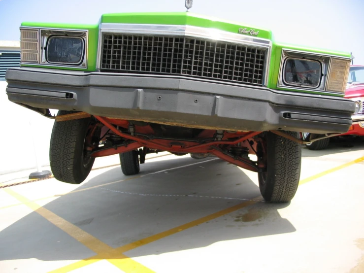 a green pick up truck sitting in the parking lot