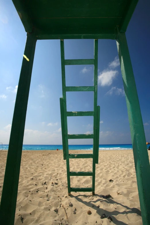 a green ladder leads into the ocean