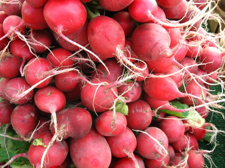 a bunch of radishes with some green leaves on them