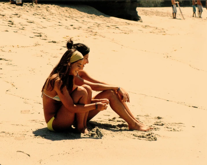 two girls are playing on the beach