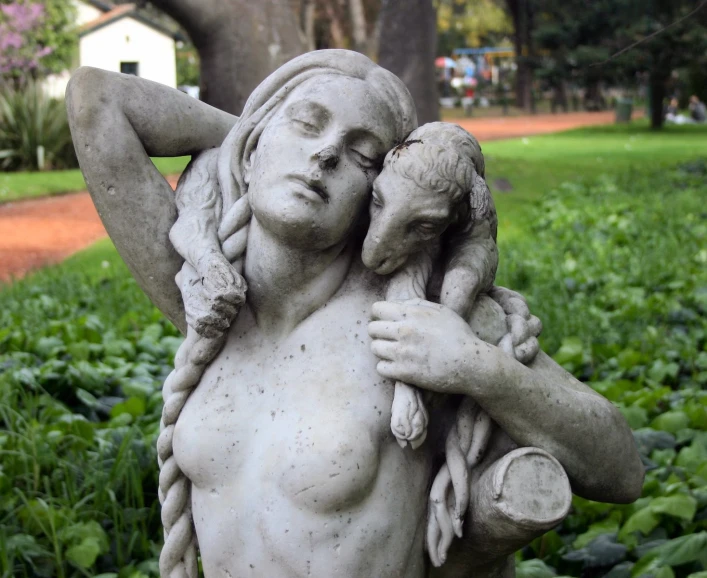 the statue is holding a lamb in his arm