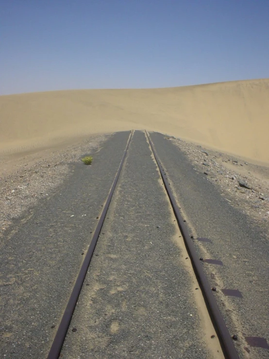 the long train tracks pass each other in the middle of the desert