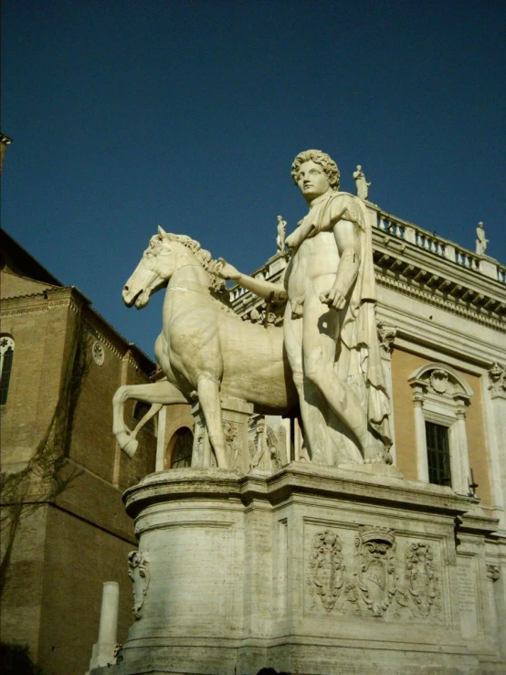 statue of a man riding a horse in front of a building