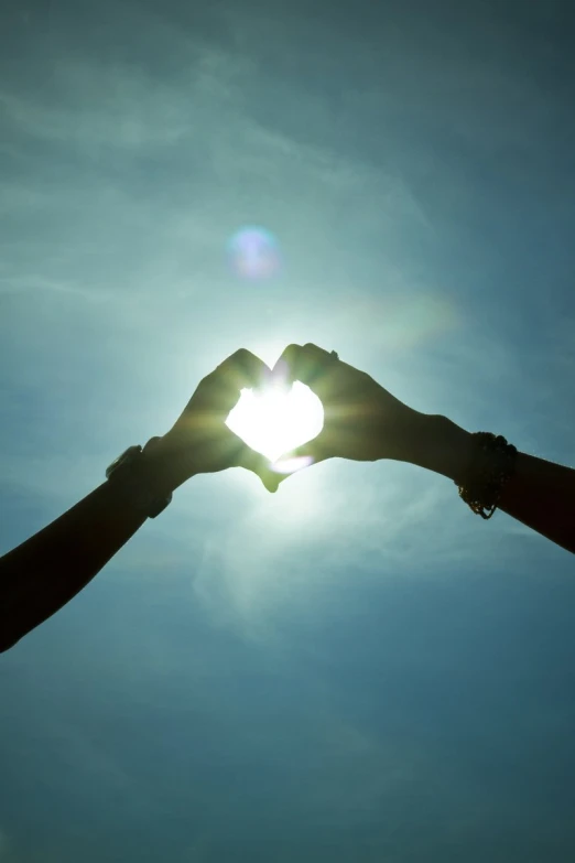 a couple of hands holding up a heart shape