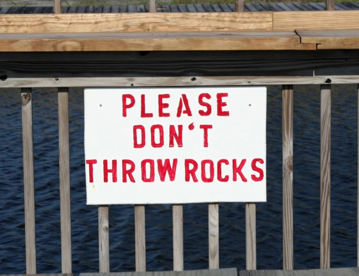 a sign posted on the side of a wooden railing
