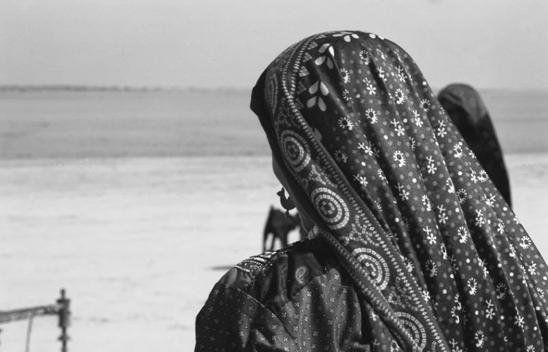 a person in patterned cloth on a beach