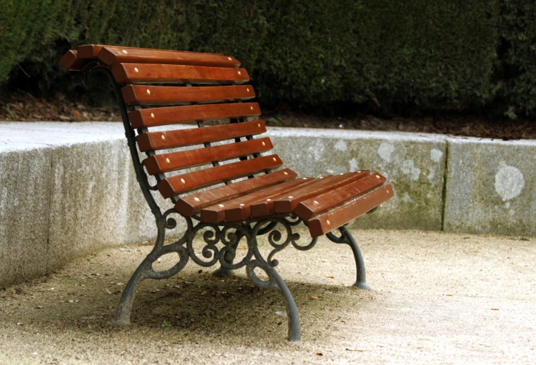 a wooden bench is located beside some concrete