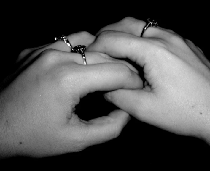 hands touching together with two ring on one hand