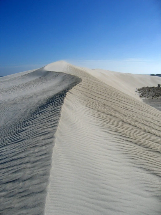 a large white sandy dune in the middle of a desert