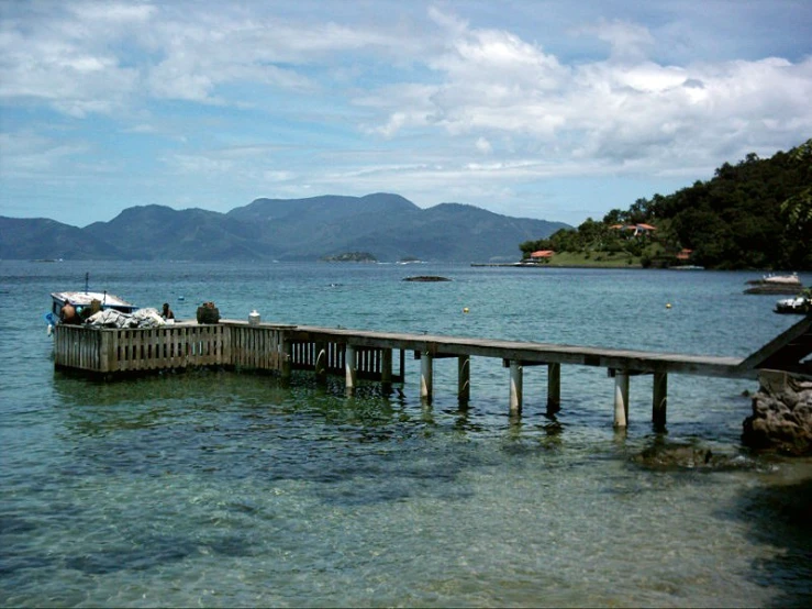 several boats are docked near the pier on the ocean