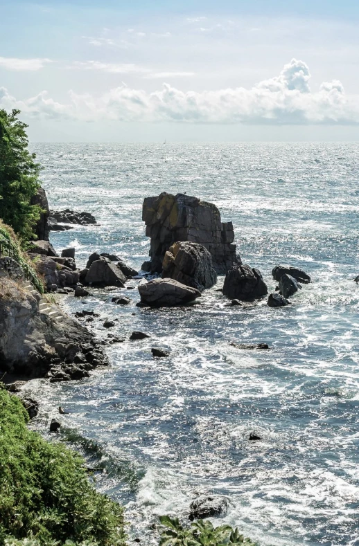 some large rocks on the water with one person out at sea