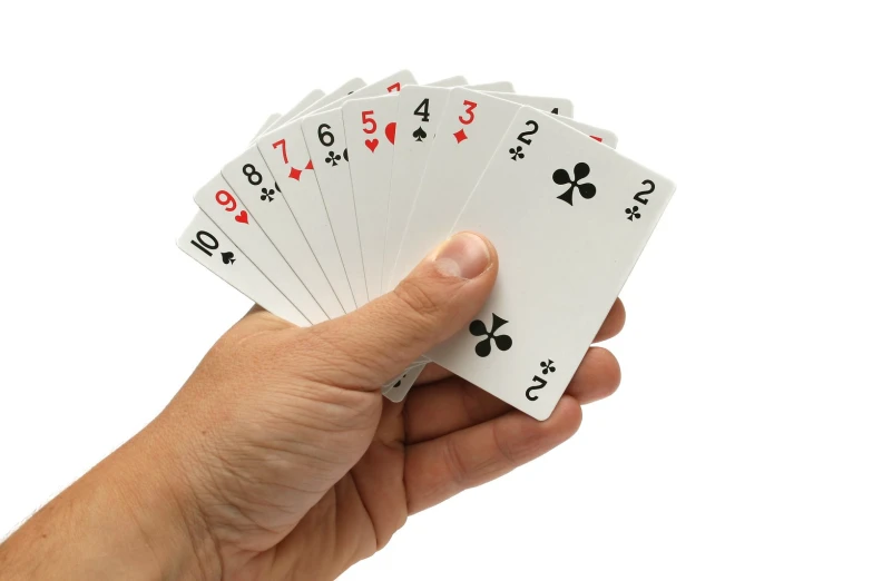 the hand holds four different playing cards