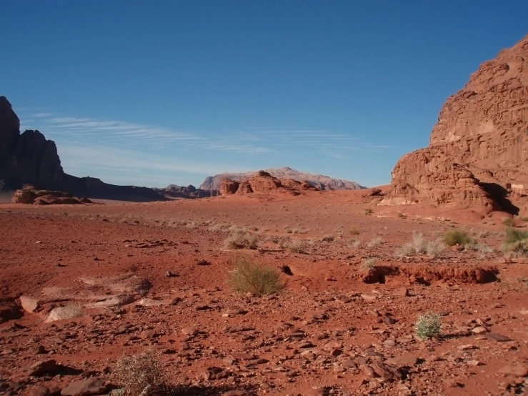 a rocky outcropping with two tall red rocks in the background