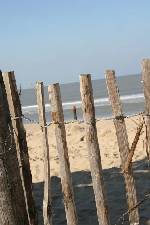 an image of beach fence that is in the foreground