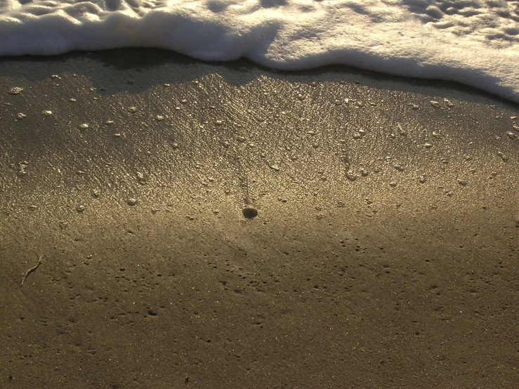 an ocean with waves coming up on sand