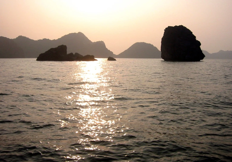 the setting sun reflects on water and islands