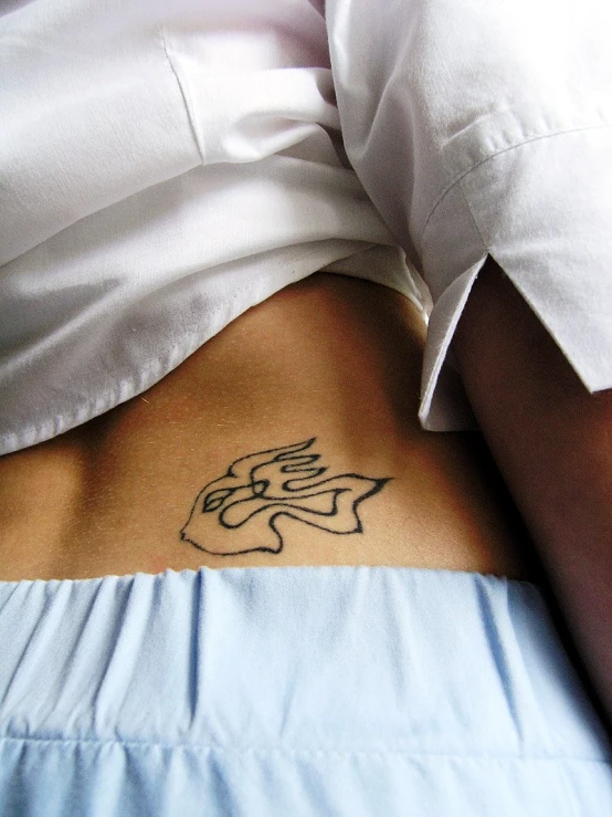 a person holding onto the side of their stomach with a tattoo