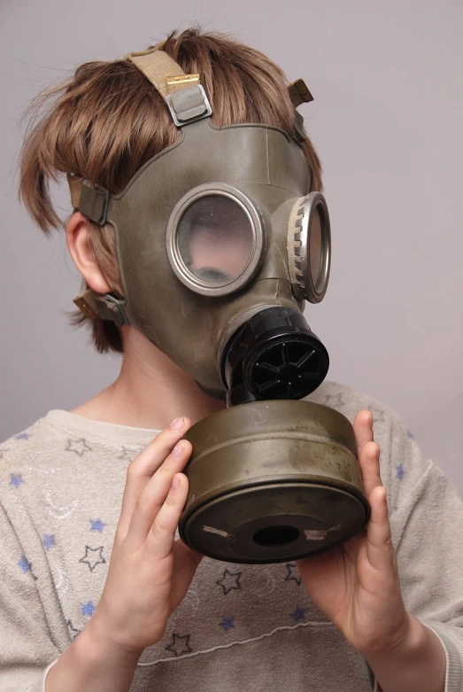 a girl wearing a gas mask and looking over her shoulder