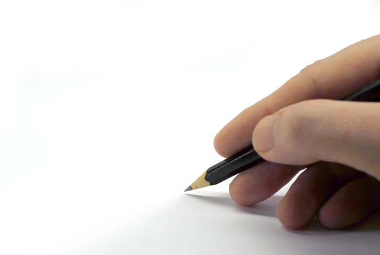 a person's hand holding a pen as they write