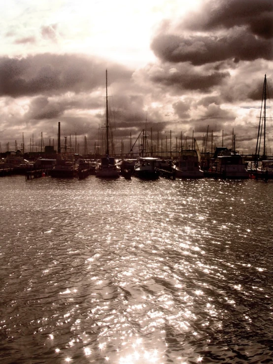 a body of water filled with boats under clouds