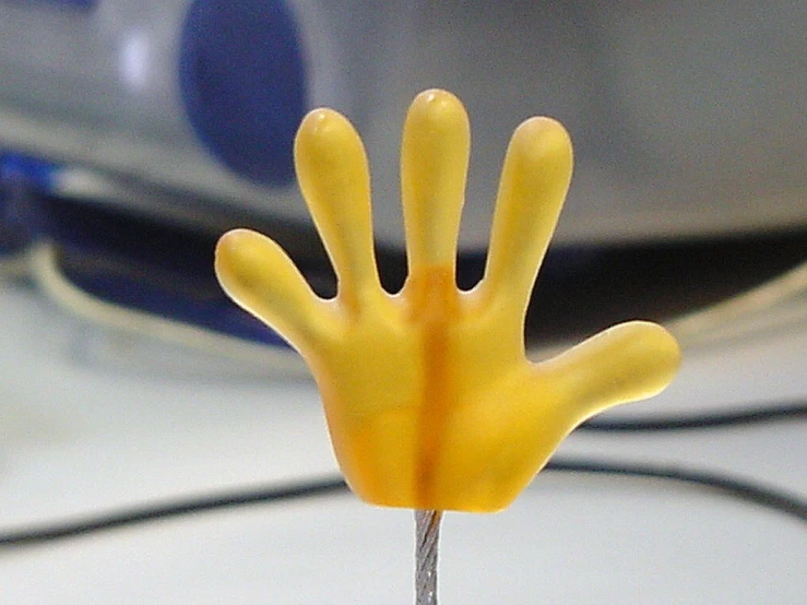 a close up of a small toy hand on a wire