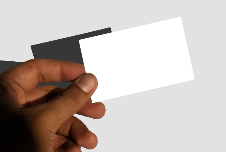 a hand holding a small white business card