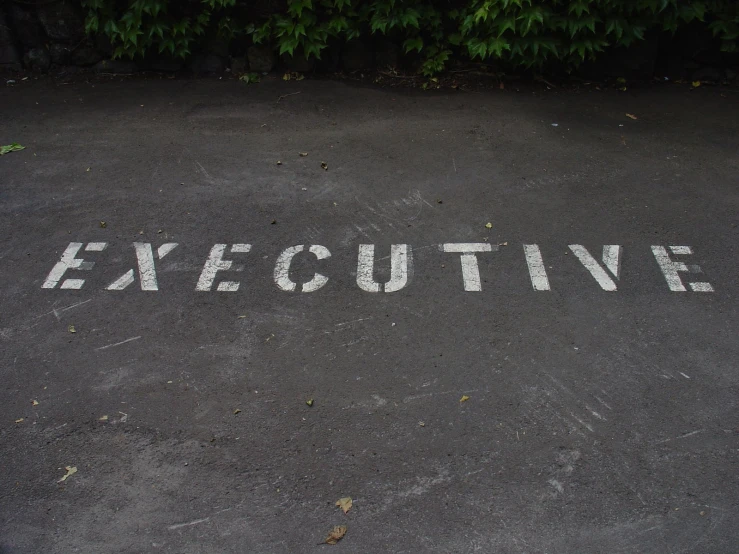 an empty parking lot with the word executive painted in white