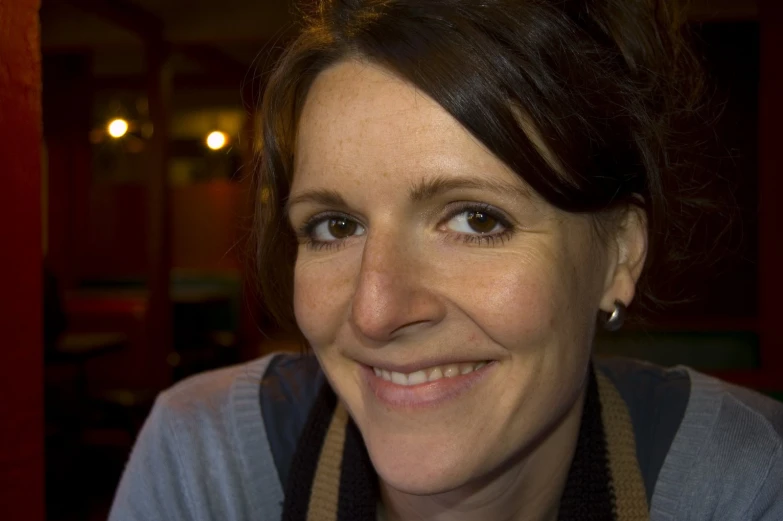 a woman smiling at the camera in front of a red wall