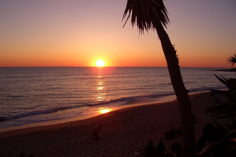 a beach at sunset with the sun setting