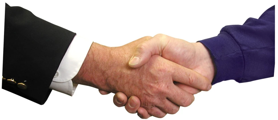 two men shaking hands with one wearing a purple jacket