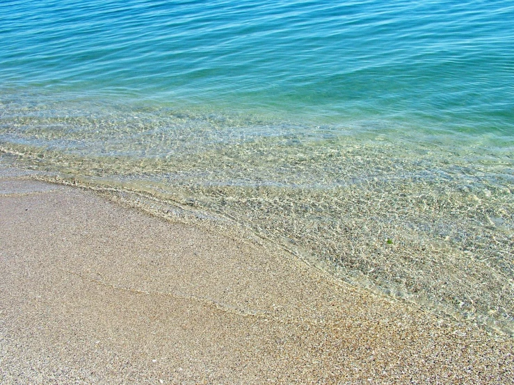 a blue and green lake is on the beach