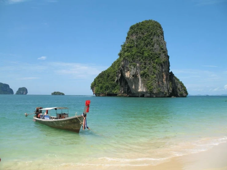 a boat in the clear blue water near an island