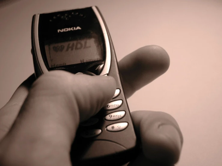 a man holding an old nokia phone and hand