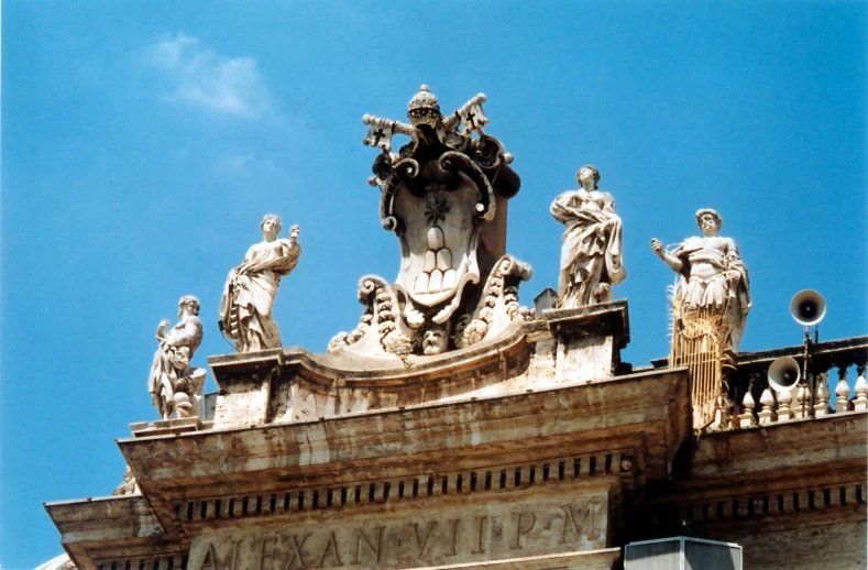 a clock tower with sculptures and clouds in the sky