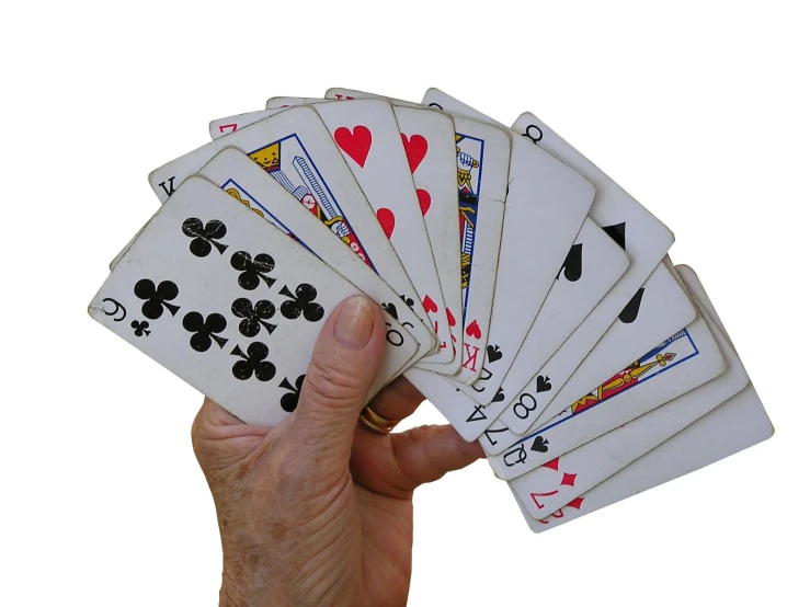 four hands holding a five card game and one hand with a lot of cards