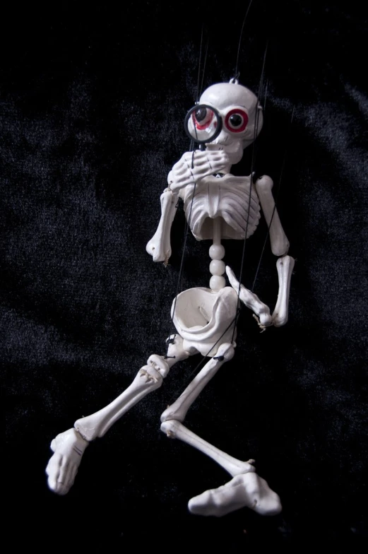 a skeleton with glasses hanging on strings