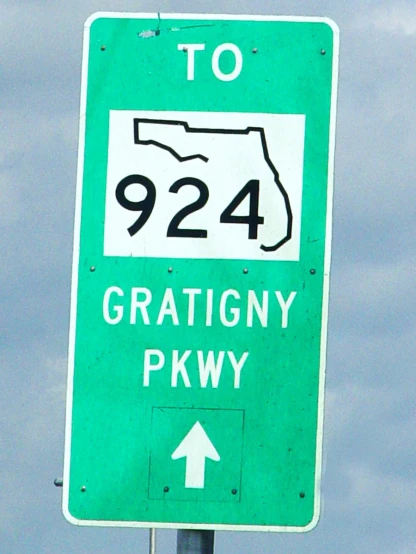 a green sign on a pole that says highway 924 gratincy parkway