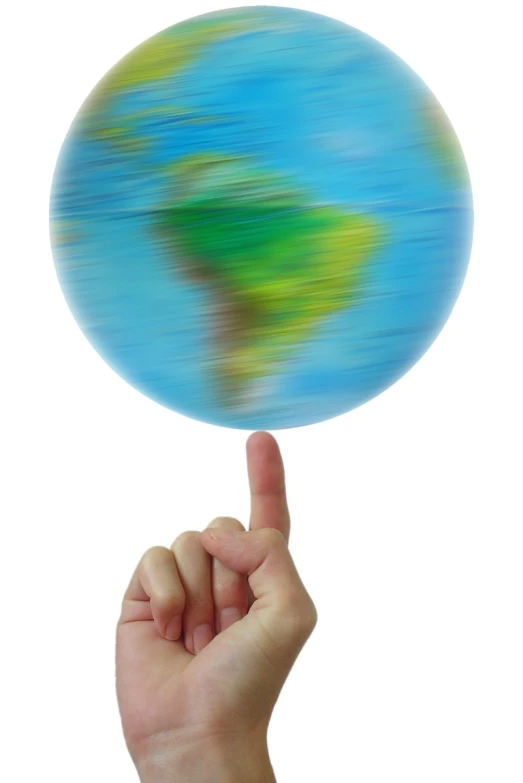 a hand holding up a small earth globe