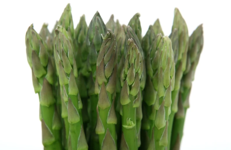 a bunch of asparagus with green tips sitting on a white background
