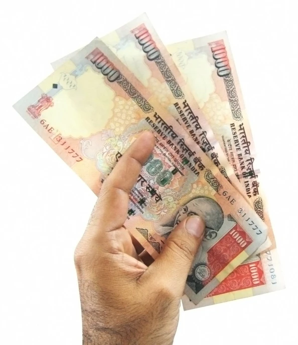 a person holding cash in their hand and some other money