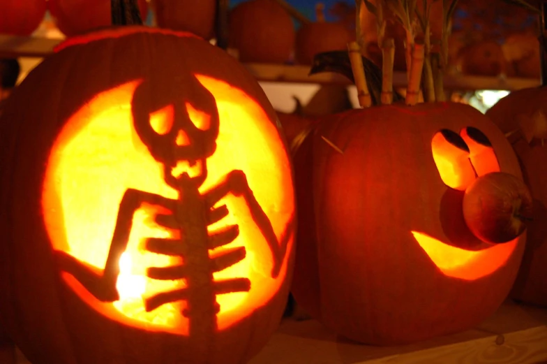 two carved pumpkins sitting in front of each other