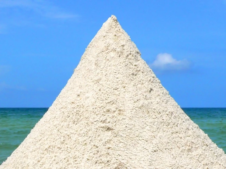 a cone made of concrete in front of the ocean