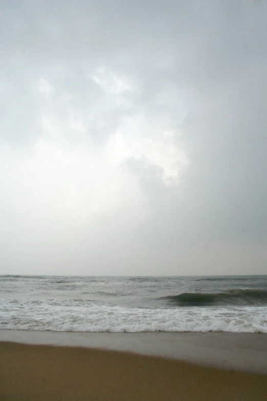 the ocean waves are crashing on the sand